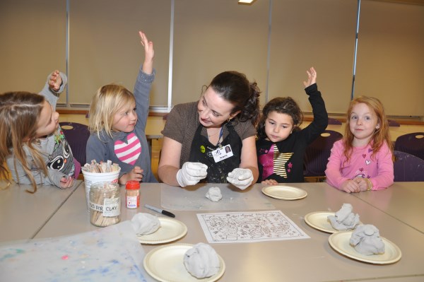 Children and their instructor working with clay