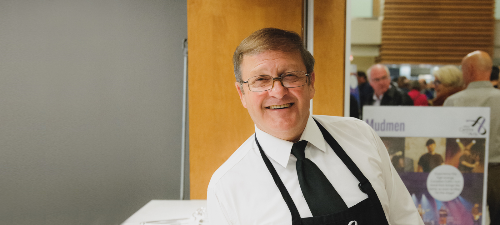 older male usher standing in the lobby