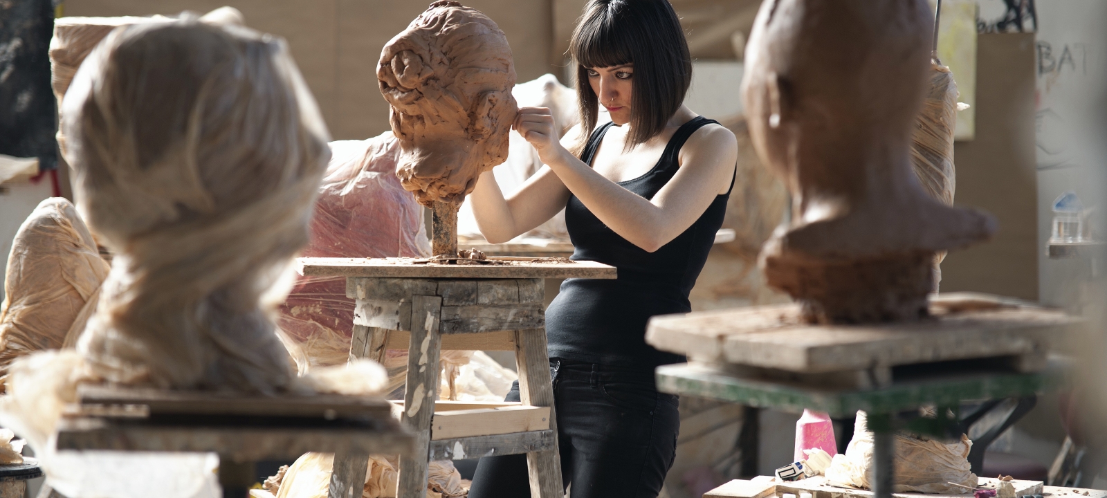 A lady sculpting heads