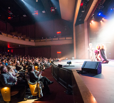 Audience members watching a performance on stage