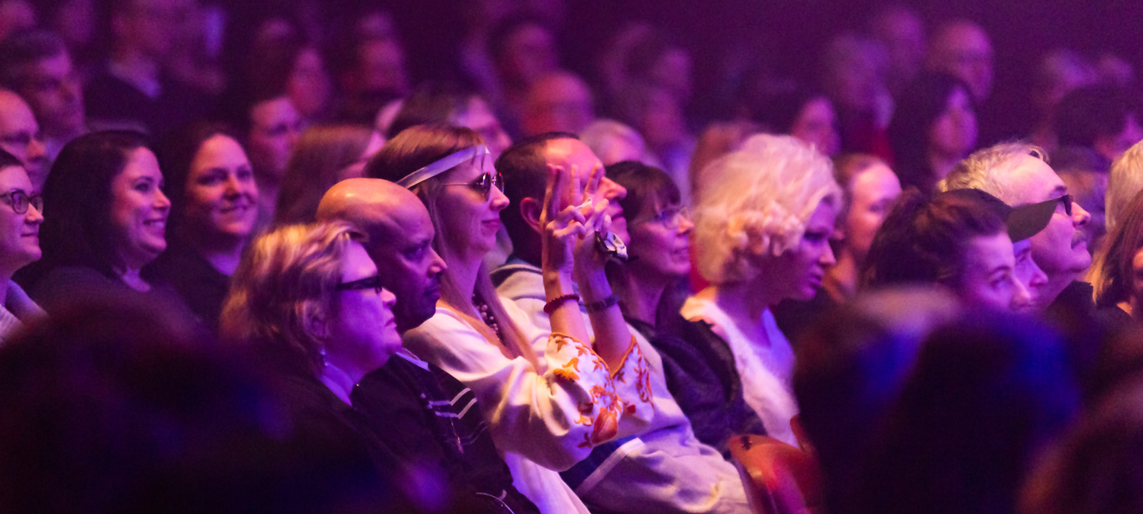 full crowd watching a performance in a theatre